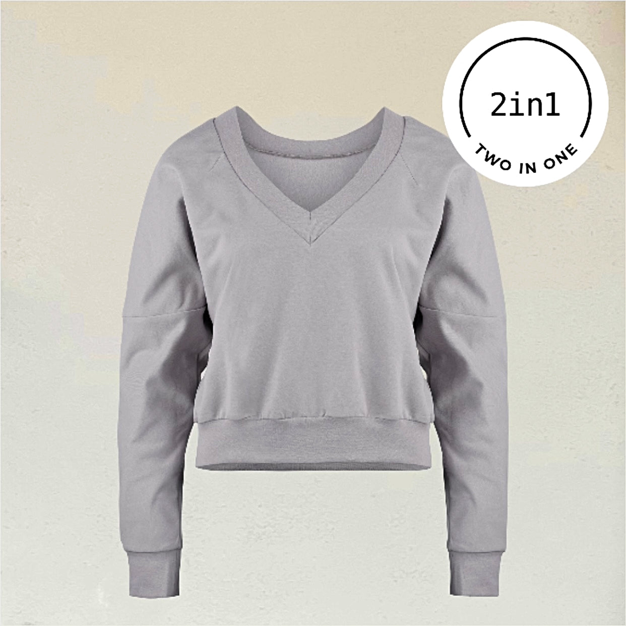 Graues Sweatshirt mit V-ausschnitt vor beiger Wand mit weißem rundem 2IN1-Icon