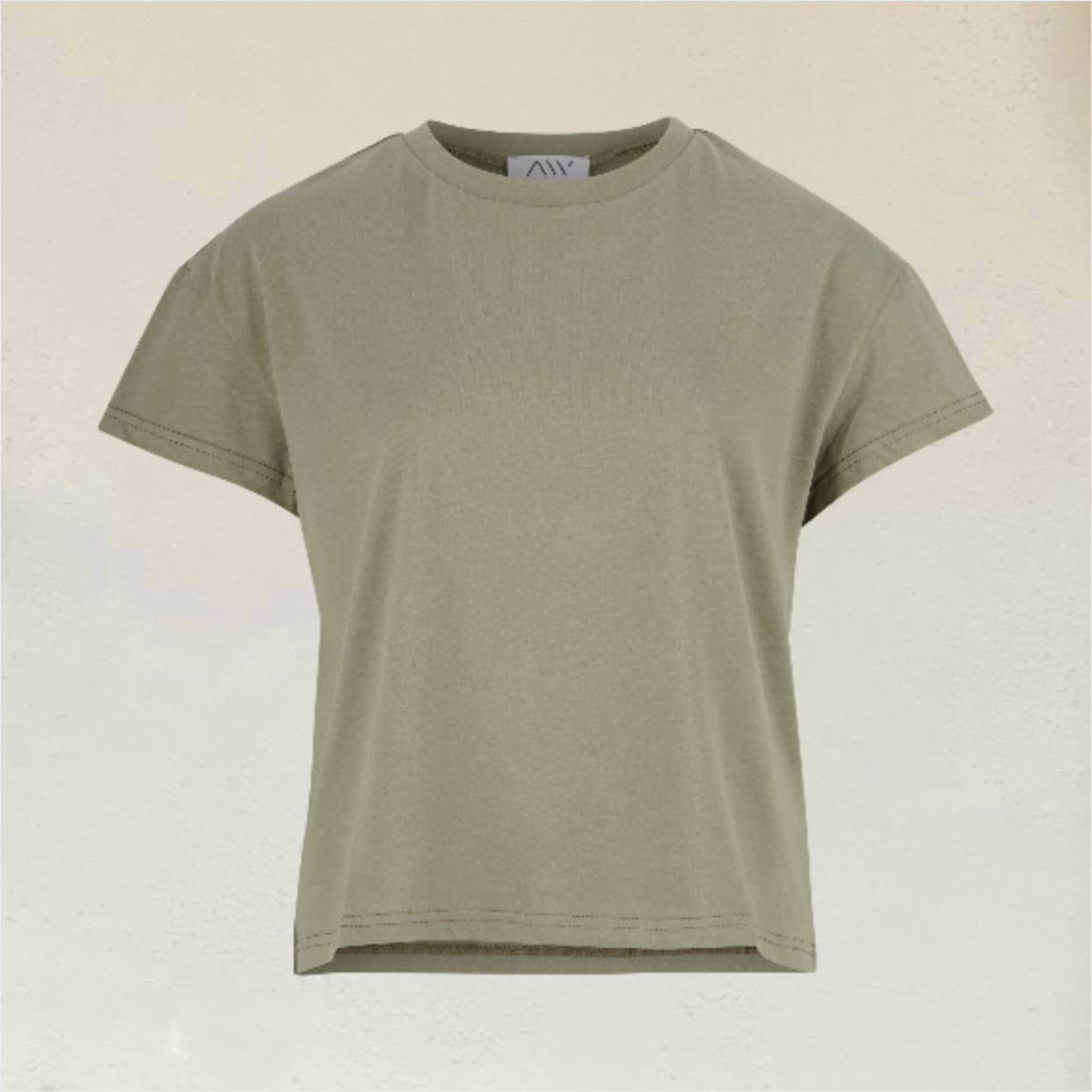 Sagefarbenes kurz geschnittenes T-Shirt vor beigem Hintergrund