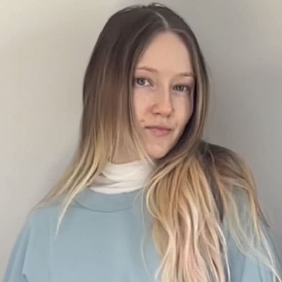 Gesicht einer blonden Frau mit langen Haaren und hellblauem Pulli