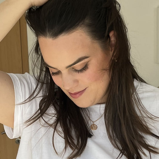 Gesicht einer dunkelhaarigen Frau mit weißem T-Shirt