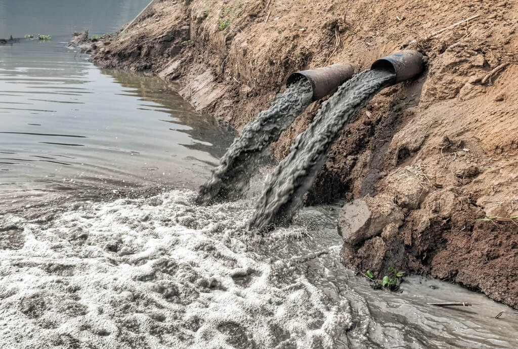 Wasserverschmuzung. Drecckiges Wasser wird in Fluss entsorgt